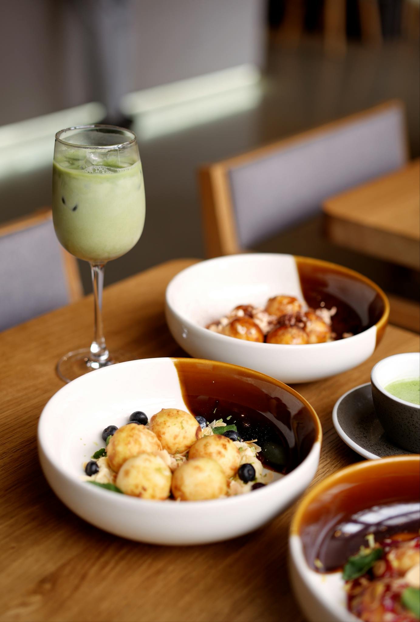 Appetizing breakfast bowls with fruit and an iced matcha drink, perfect for dining inspiration.
