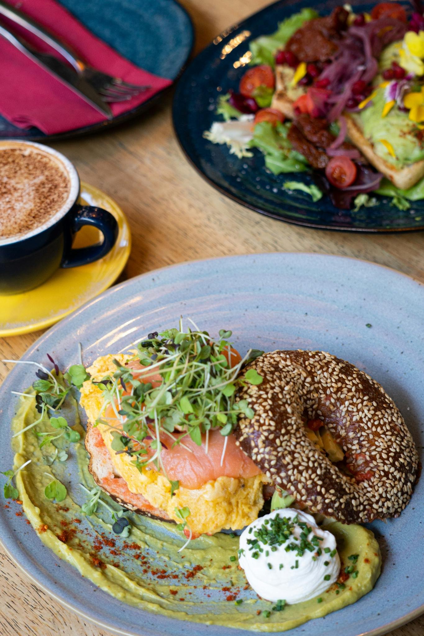 Tasty sesame bagel with salmon, avocado, and greens, perfect for brunch.